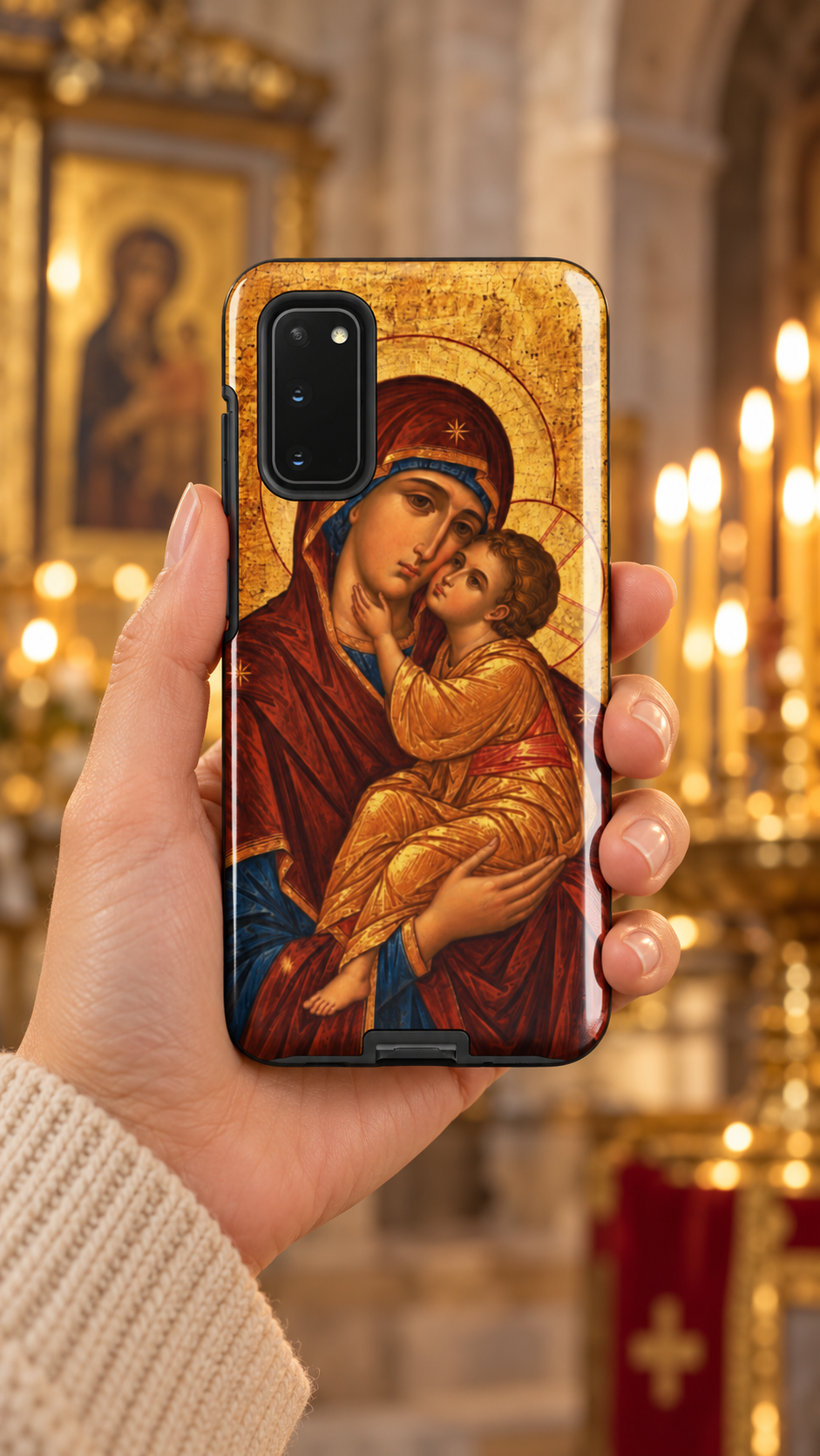 Hand holding a Samsung Galaxy in the Theotokos Byzantine icon tough case inside a candlelit church